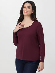 Woman wearing a burgundy long-sleeve top on a white background