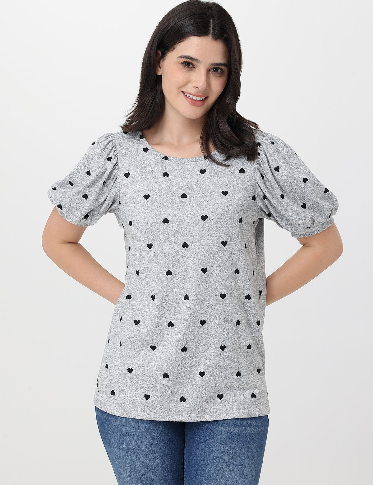 Woman wearing a gray top with black heart patterns on a white background