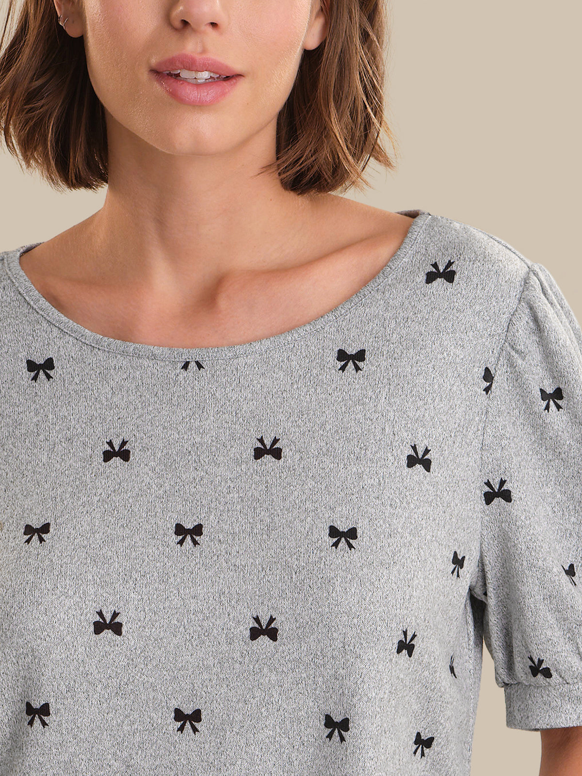 Gray top with black bow pattern worn by a person