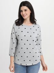 Woman wearing a gray sweater with black heart patterns on a white background