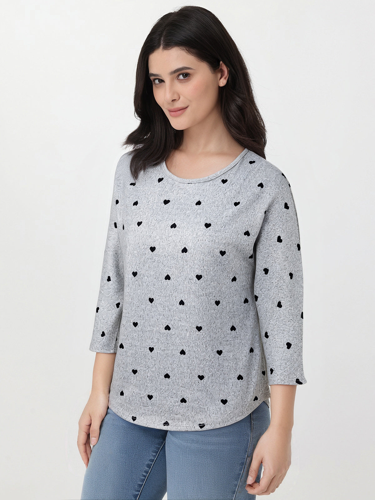 Woman wearing a gray sweater with black heart patterns on a white background
