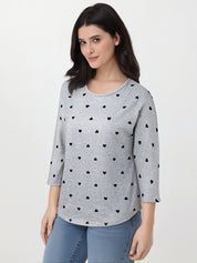 Woman wearing a gray sweater with black heart patterns on a white background
