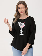 Woman wearing a black oversized shirt with a graphic design on a white background