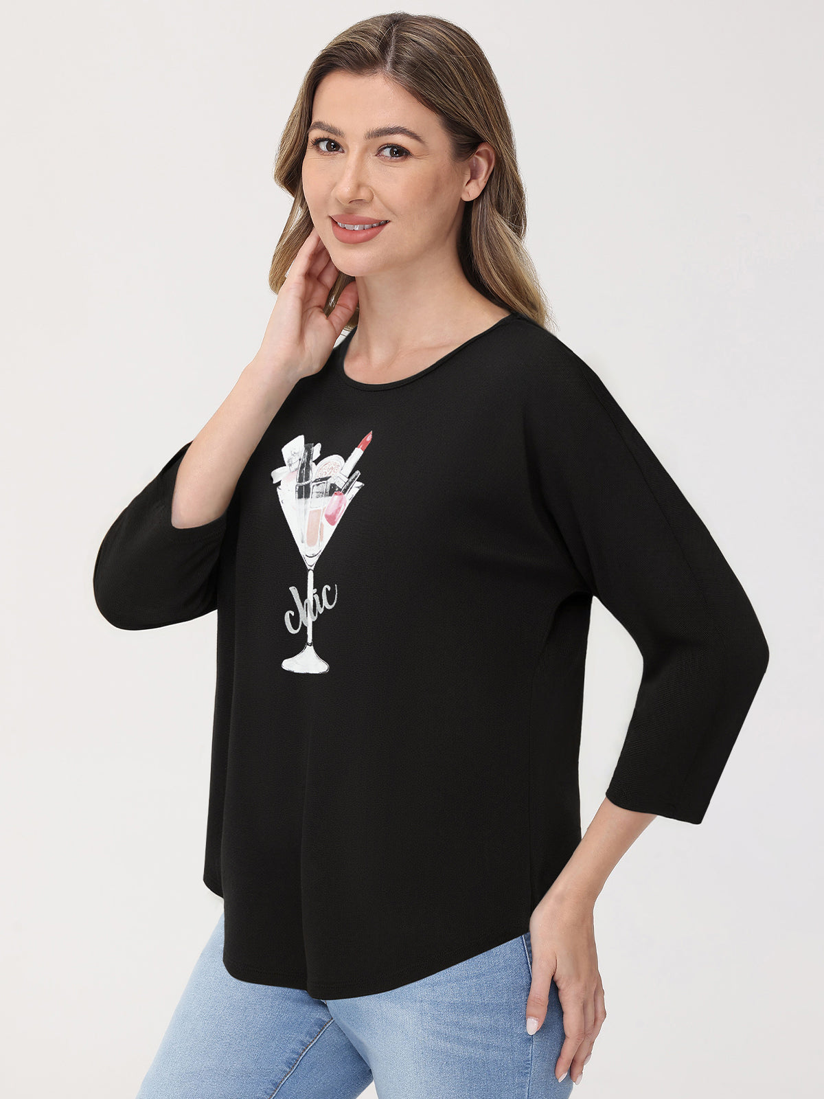 Woman wearing a black top with a graphic design on a white background