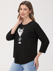 Woman wearing a black top with a graphic design on a white background