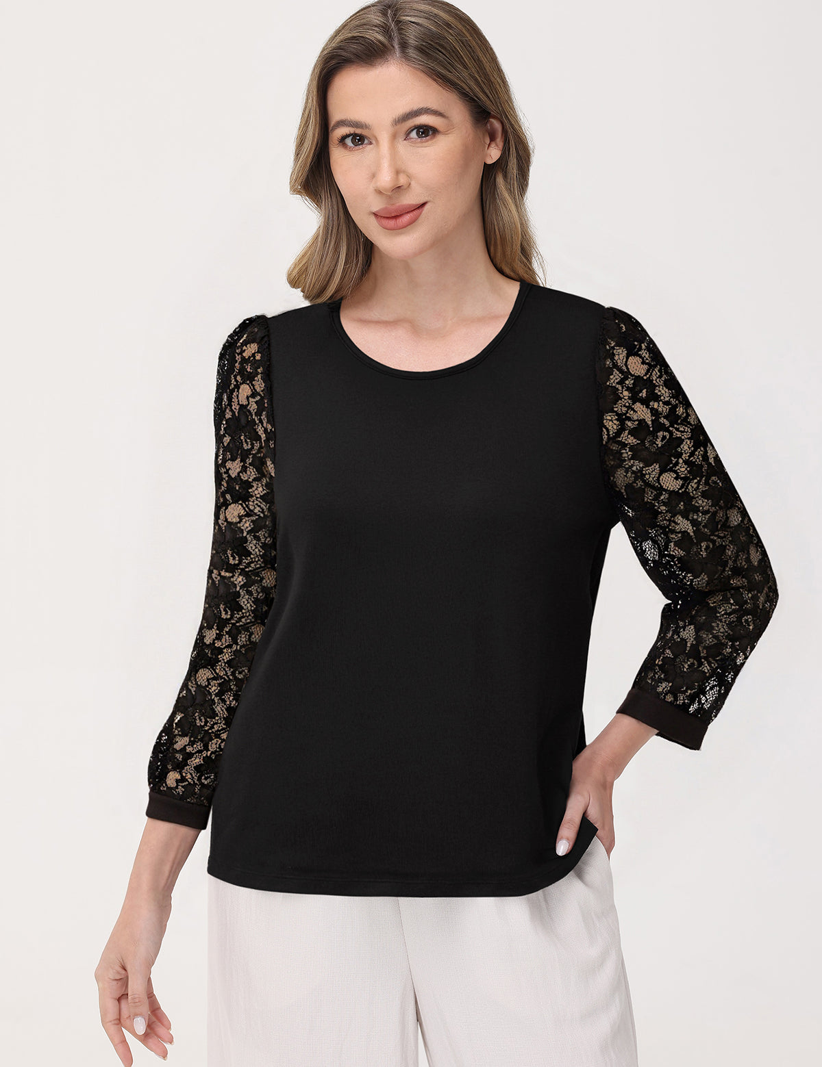 Woman wearing a black top with lace sleeves on a white background