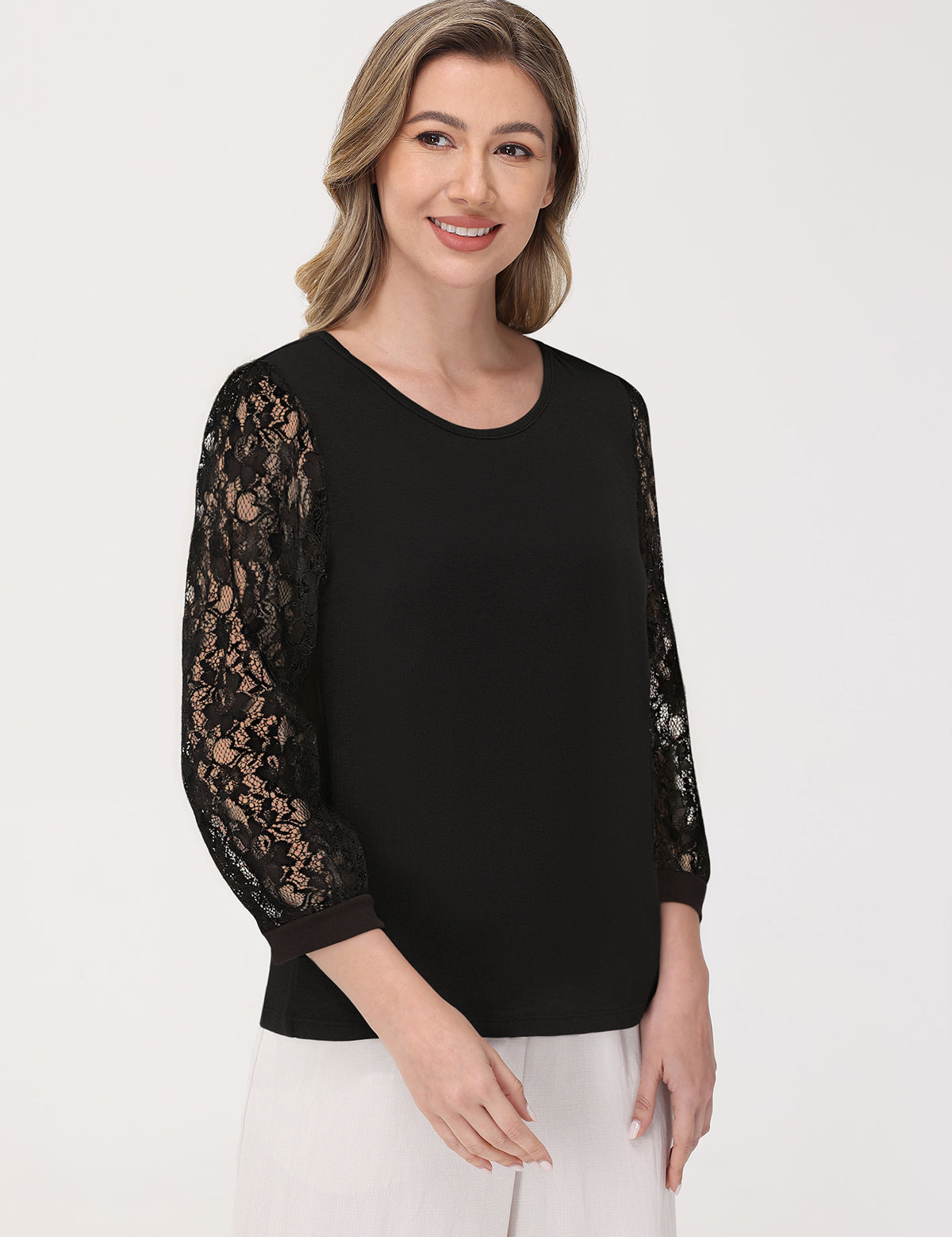 Woman wearing a black top with lace sleeves on a white background