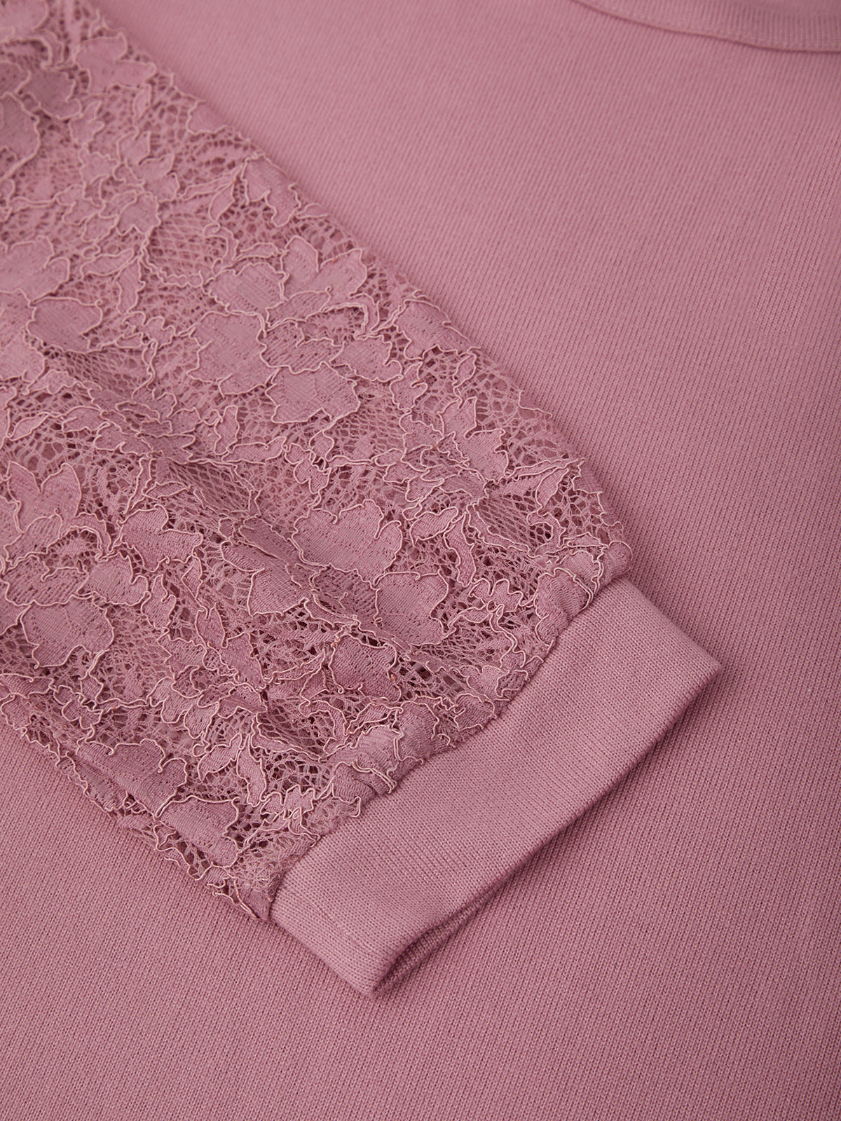 Pink garment with lace detailing on a matching fabric background