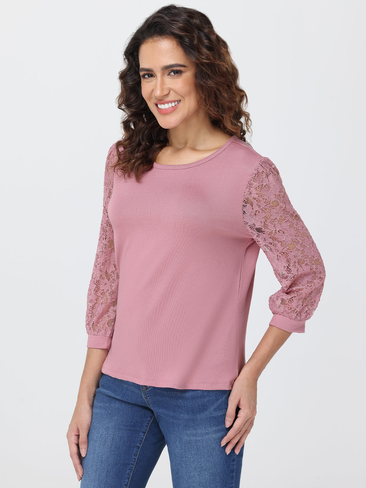 Woman wearing a pink top with lace sleeves on a white background