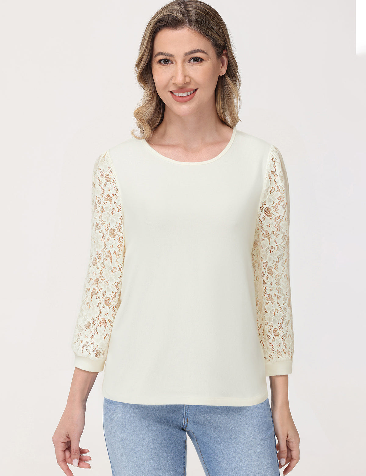 Woman wearing a white blouse with lace sleeves on a plain background