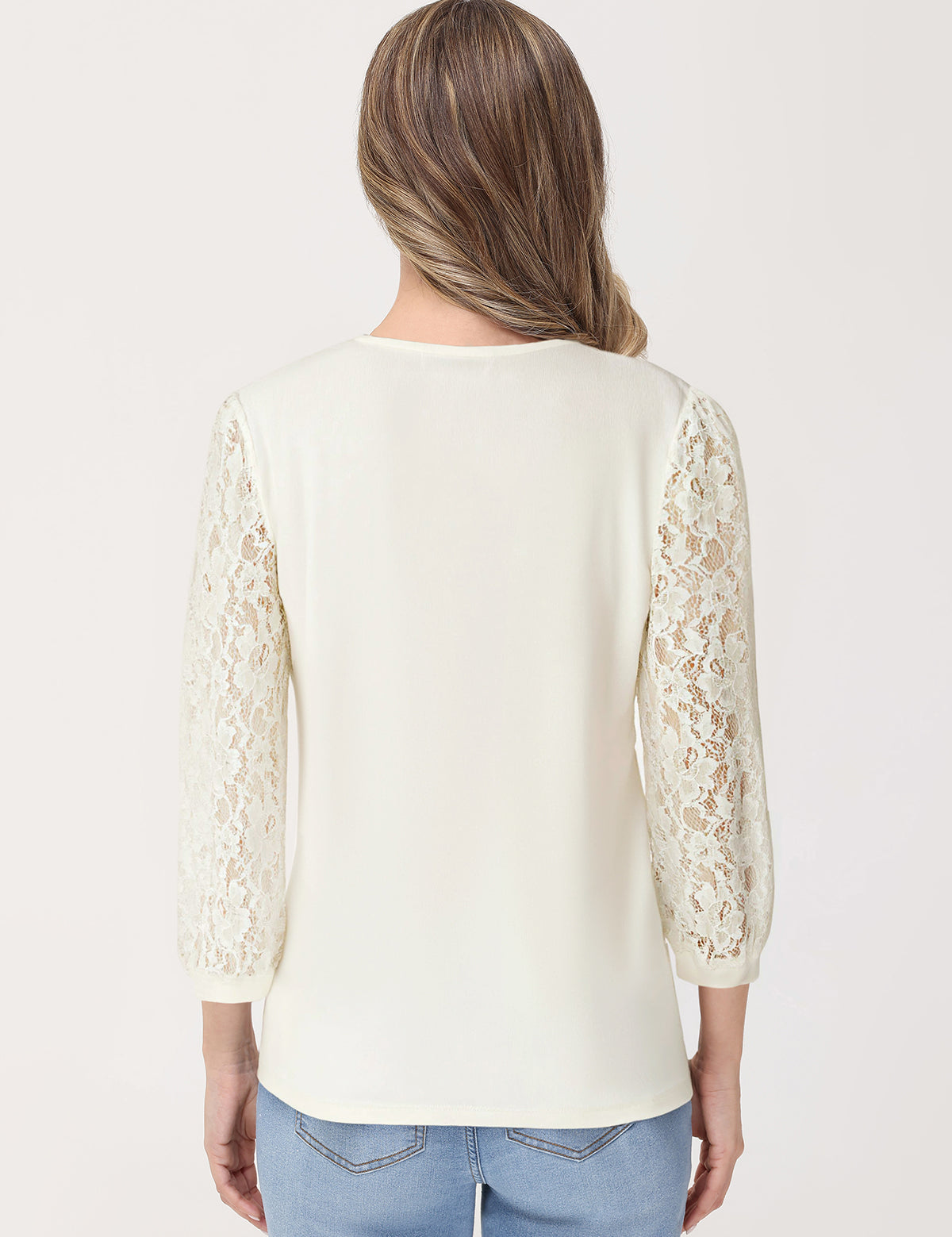 Woman wearing a cream lace top with long sleeves on a white background