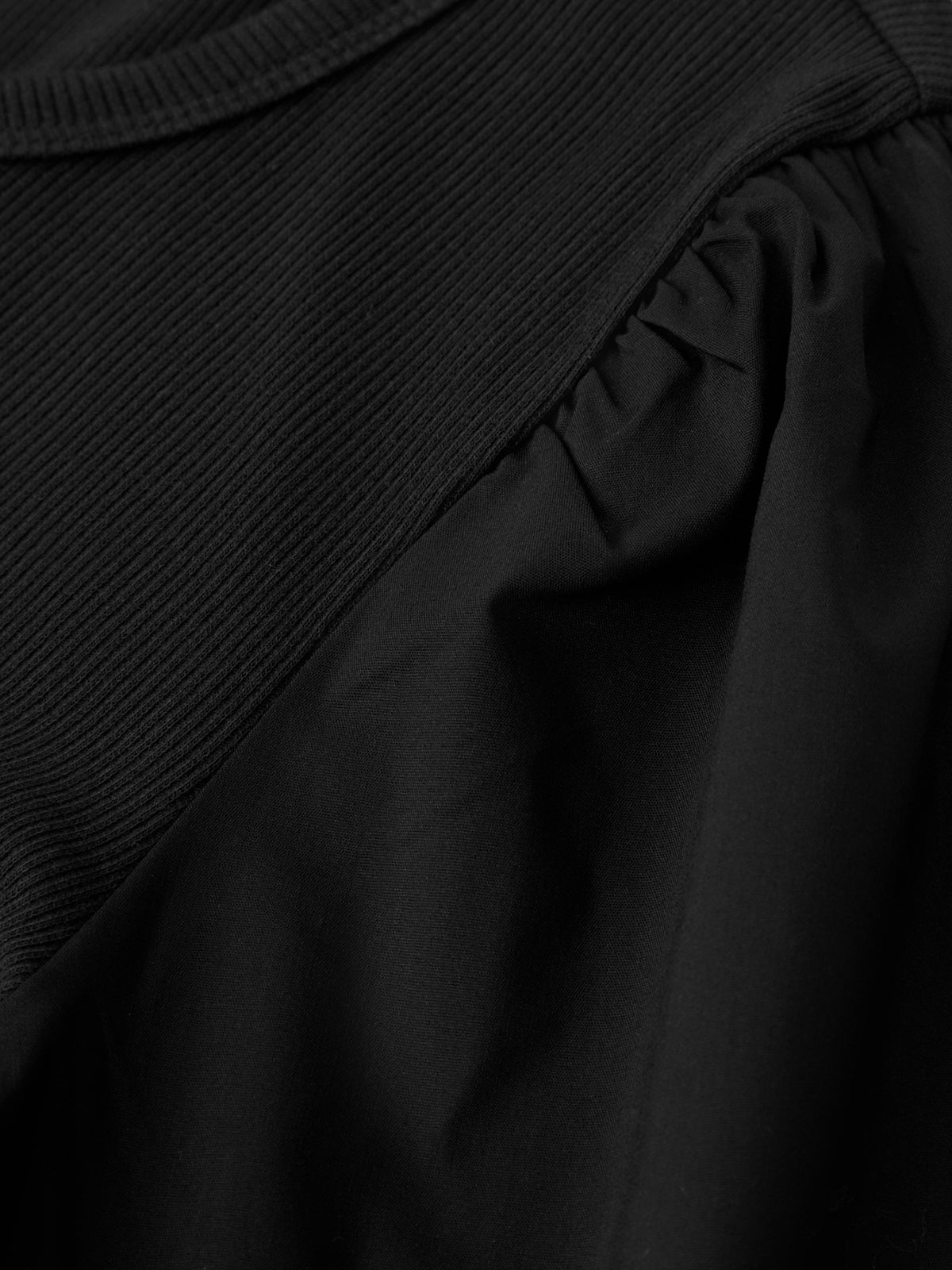 Close-up of a black garment with ruffled details