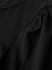 Close-up of a black garment with ruffled details