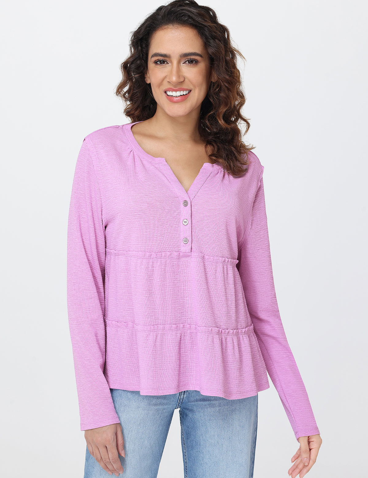 Woman wearing a pink long-sleeve top with a white background