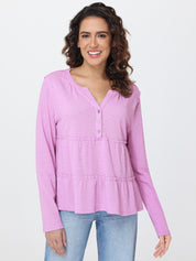 Woman wearing a pink long-sleeve top with a white background
