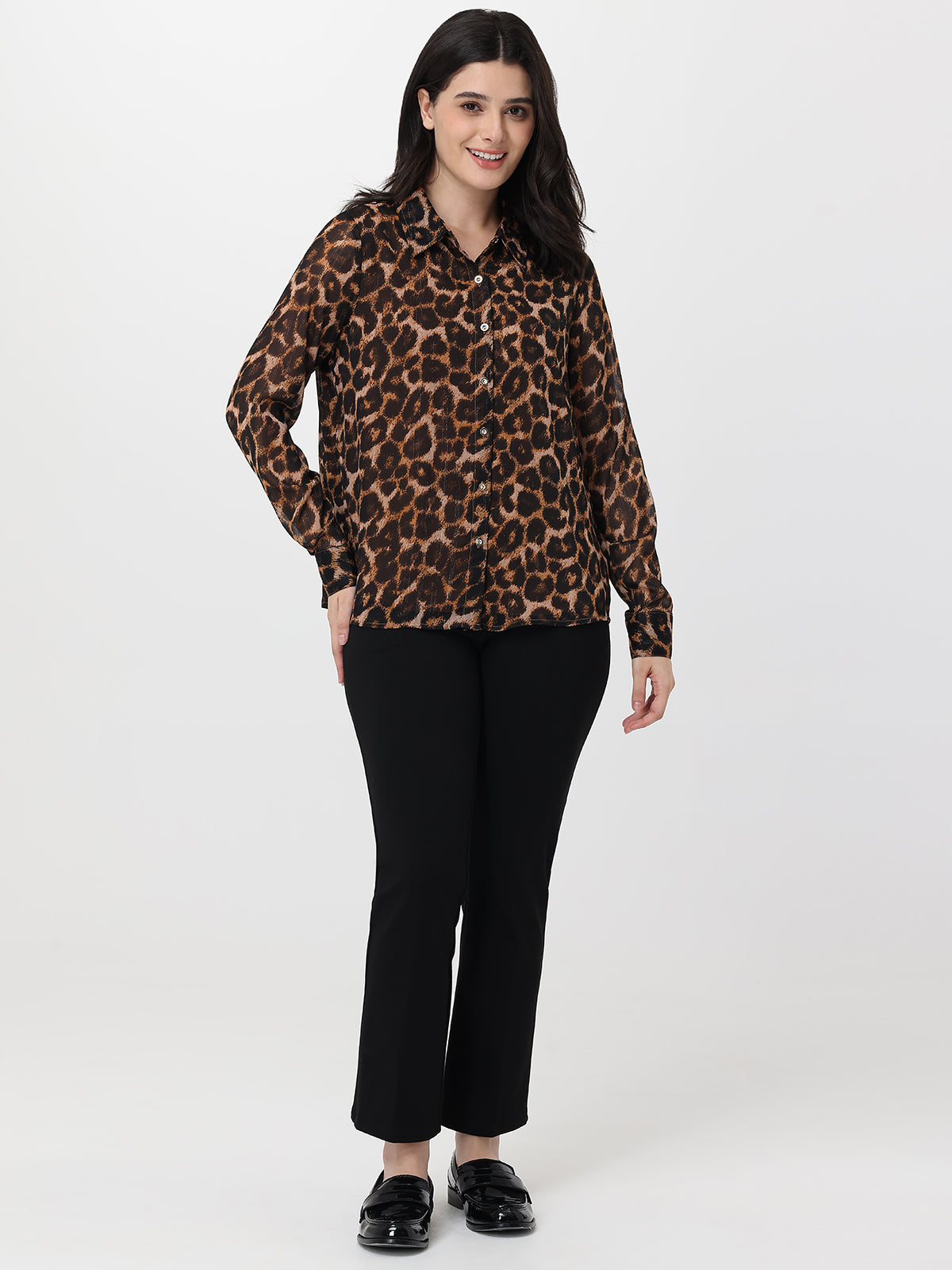 Woman wearing a leopard print shirt and black pants on a white background