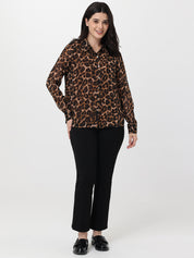 Woman wearing a leopard print shirt and black pants on a white background