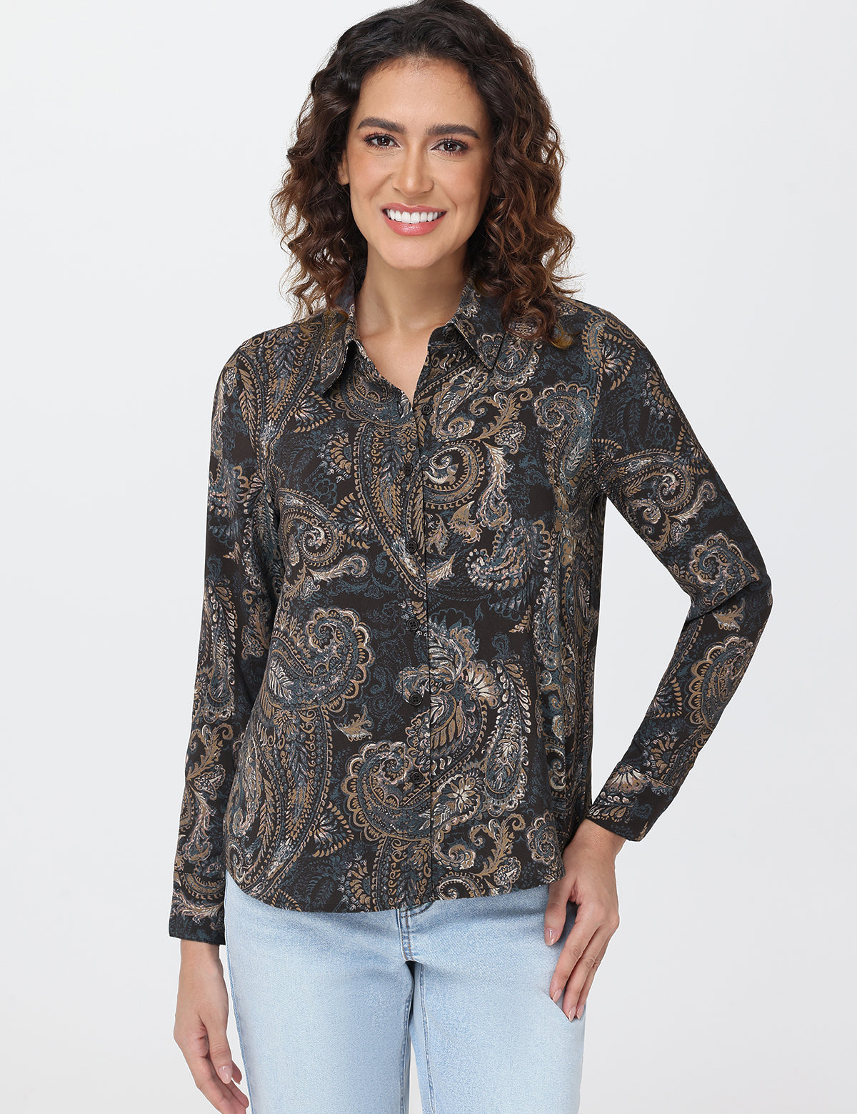 Woman wearing a patterned shirt and light blue jeans on a white background