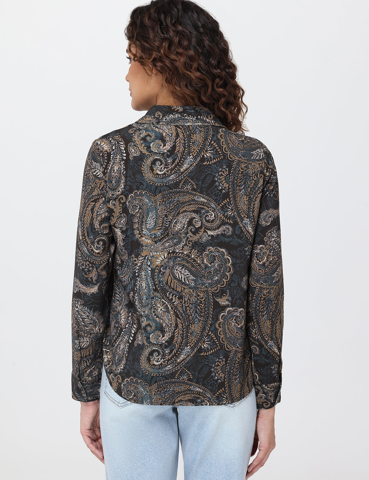 Woman wearing a patterned shirt with a plain background