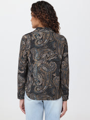 Woman wearing a patterned shirt with a plain background