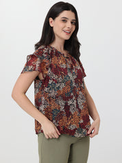 Woman wearing a patterned top with a plain background