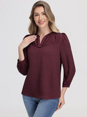 Woman wearing a burgundy blouse with long sleeves on a white background