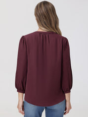 Maroon blouse worn by a person on a plain background