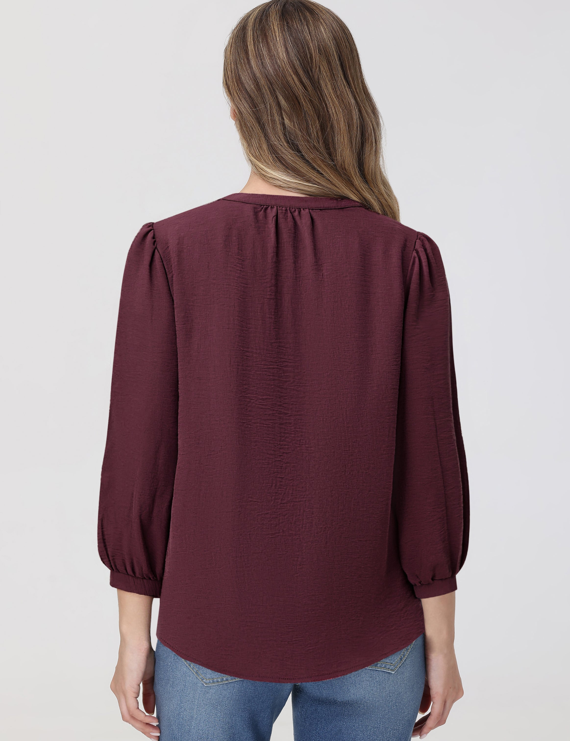 Maroon blouse worn by a person on a plain background
