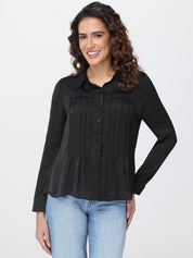 Woman wearing a black blouse and blue jeans on a white background