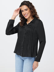 Woman wearing a black blouse and light blue jeans on a white background