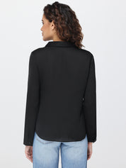 Woman wearing a black shirt and light blue jeans on a white background