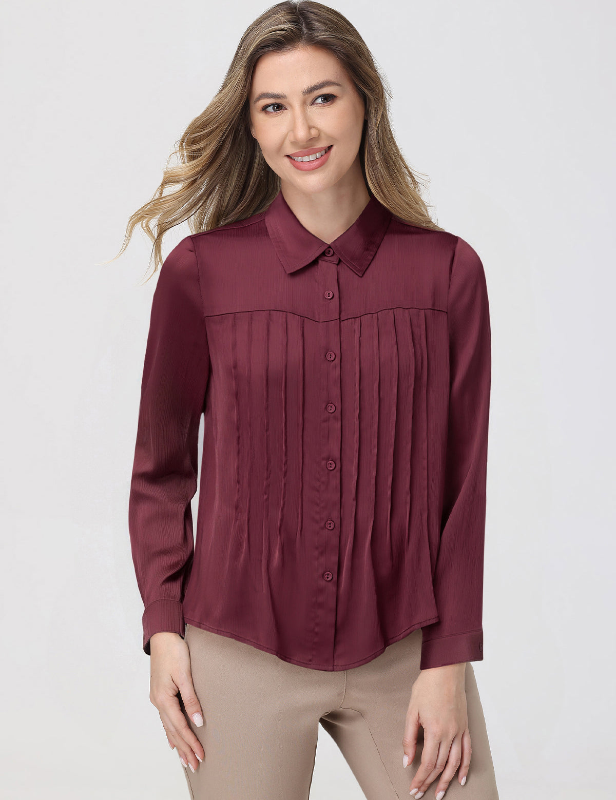 Woman wearing a burgundy blouse with a plain background