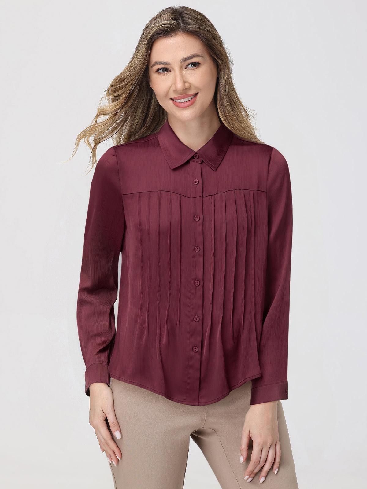 Woman wearing a burgundy blouse with a plain background