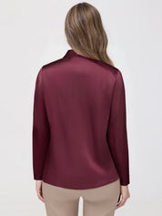 Maroon satin blouse worn by a person on a white background