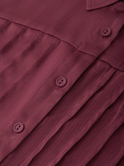 Close-up of a maroon shirt with buttons on a matching fabric background