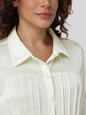 Close-up of a person wearing a light-colored shirt with a neutral background