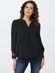 Woman wearing a black blouse with lace cuffs on a white background