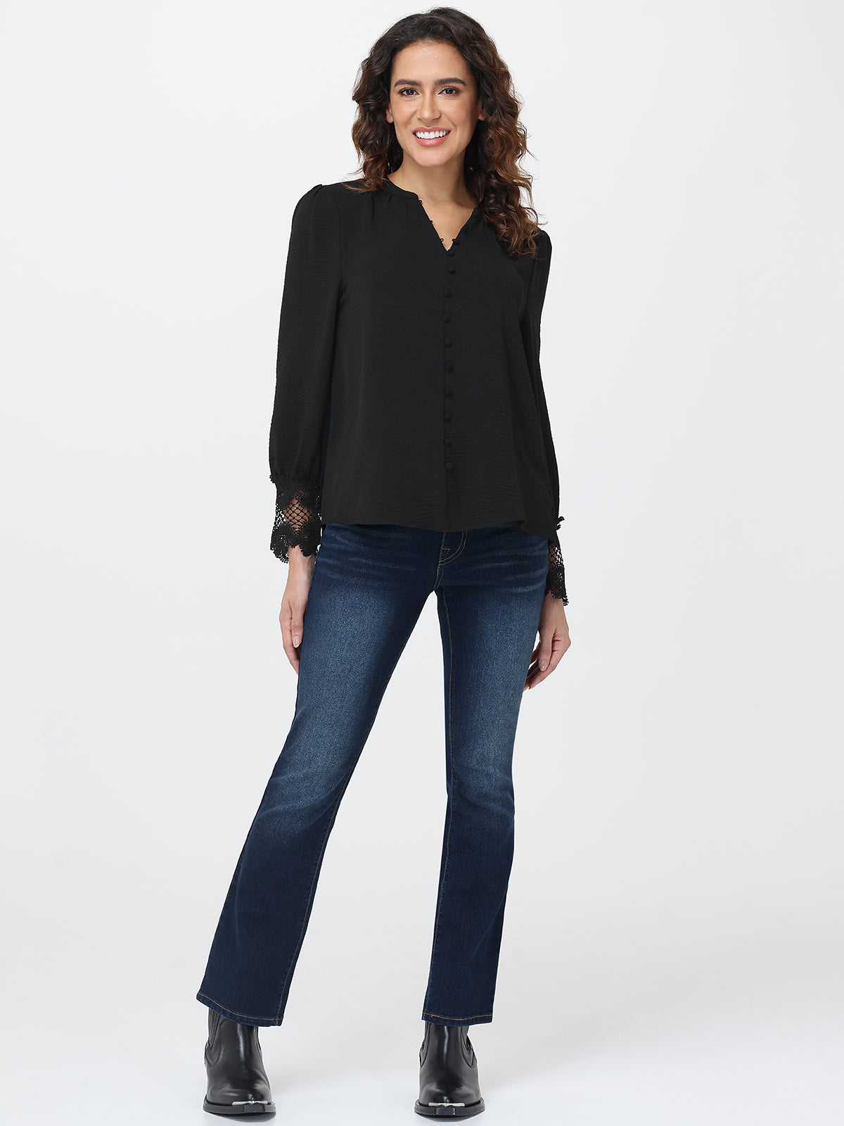 Woman wearing a black blouse and blue jeans on a white background