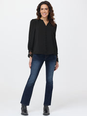 Woman wearing a black blouse and blue jeans on a white background