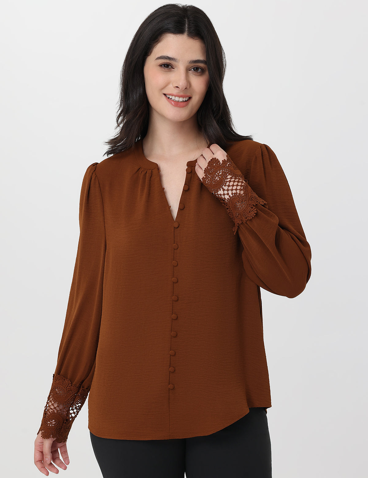 Woman wearing a brown blouse with lace sleeves on a white background