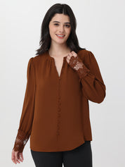 Woman wearing a brown blouse with lace sleeves on a white background