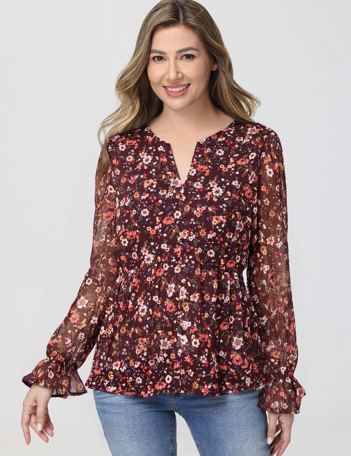 Woman wearing a floral blouse with long sleeves on a white background