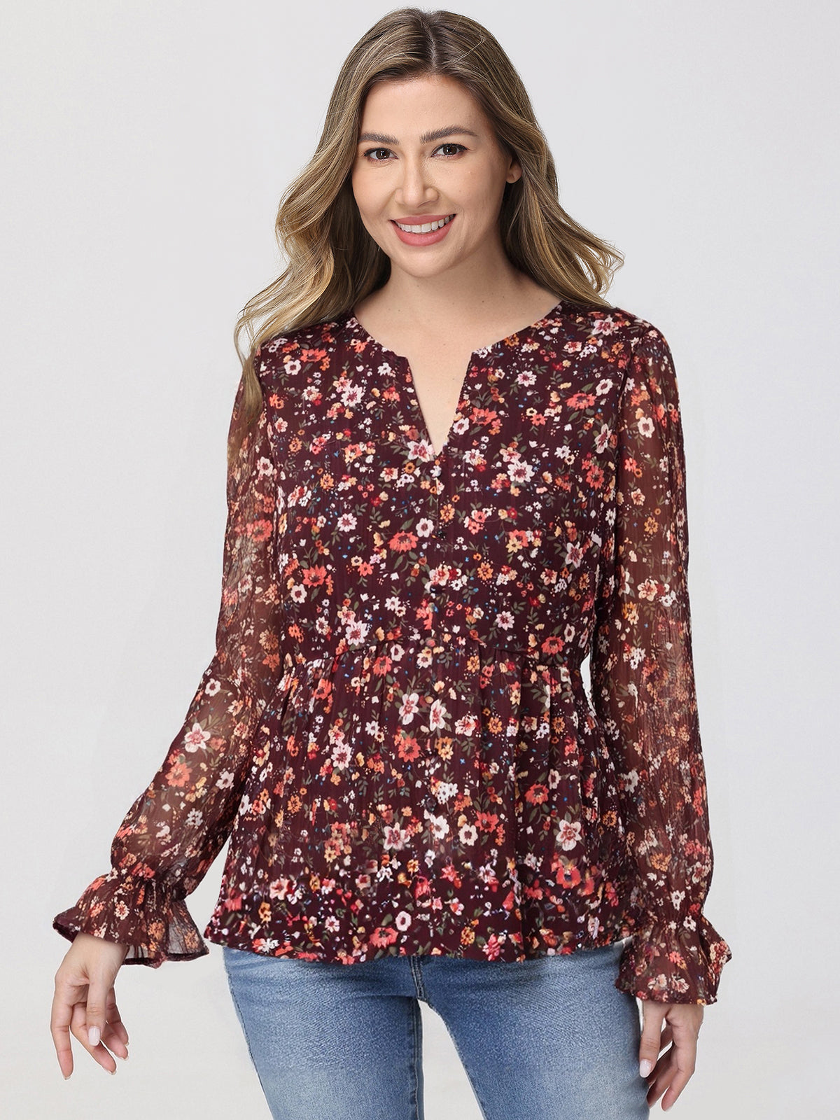 Woman wearing a floral blouse with long sleeves on a white background