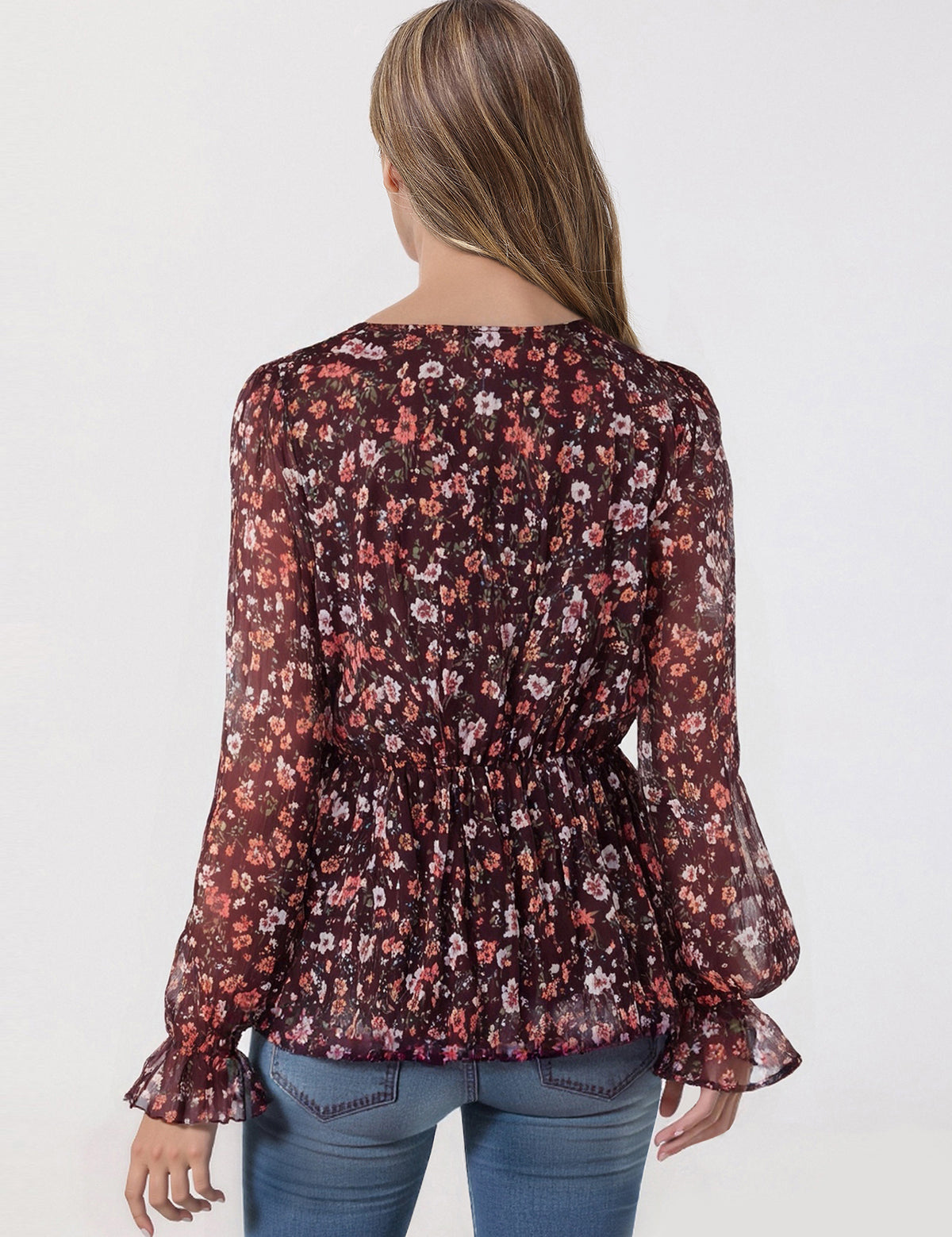 Woman wearing a floral blouse with long sleeves on a white background