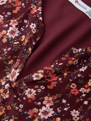 Close-up of floral fabric with a visible brand label on a dark red background