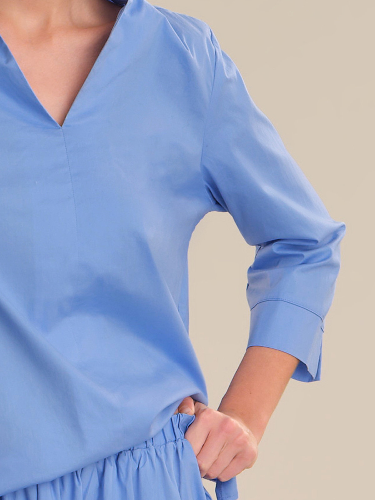 Blue blouse with long sleeves on a neutral background