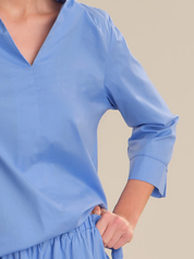 Blue blouse with long sleeves on a neutral background