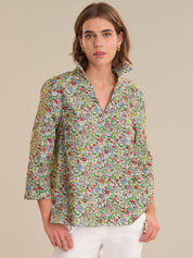 Woman wearing a floral patterned shirt against a beige background