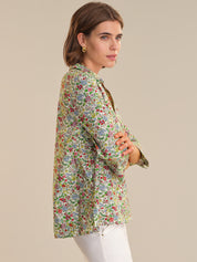 Woman wearing a floral print shirt against a beige background