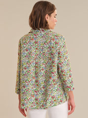 Woman wearing a floral patterned blouse against a beige background